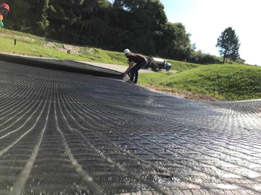 Geogrelha Spalla sendo desenrolada sobre a pista